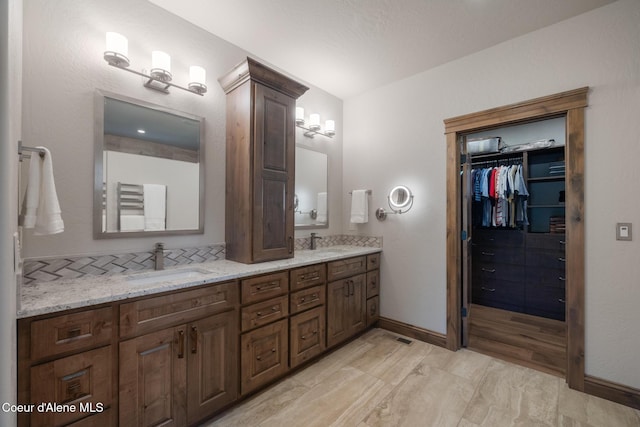 11671 N Spiraea Ln, Hayden, ID 83835 - full bathroom with double vanity, baseboards, and a walk in closet