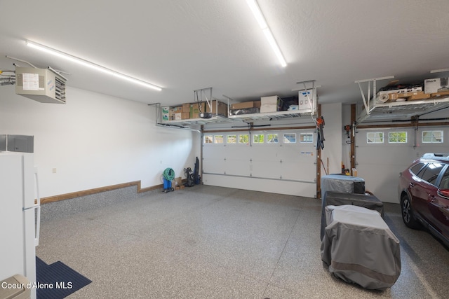 11671 N Spiraea Ln, Hayden, ID 83835 - garage with freestanding refrigerator, a garage door opener, and a heating unit