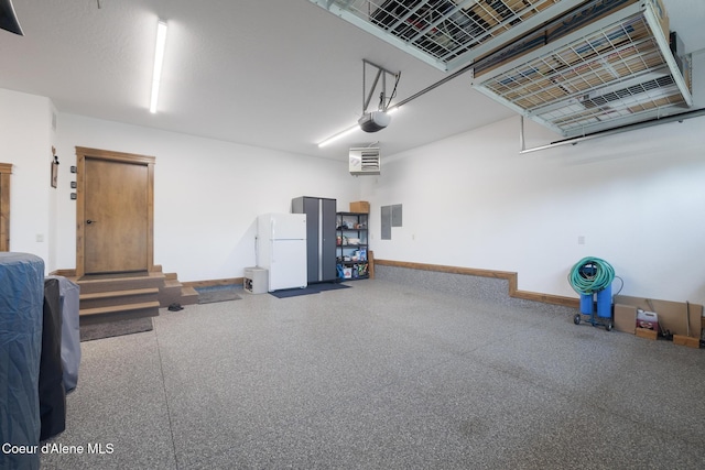 11671 N Spiraea Ln, Hayden, ID 83835 - garage featuring baseboards, a garage door opener, and freestanding refrigerator