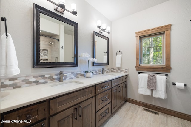 11671 N Spiraea Ln, Hayden, ID 83835 - bathroom with double vanity, decorative backsplash, a shower, baseboards, and wood finished floors