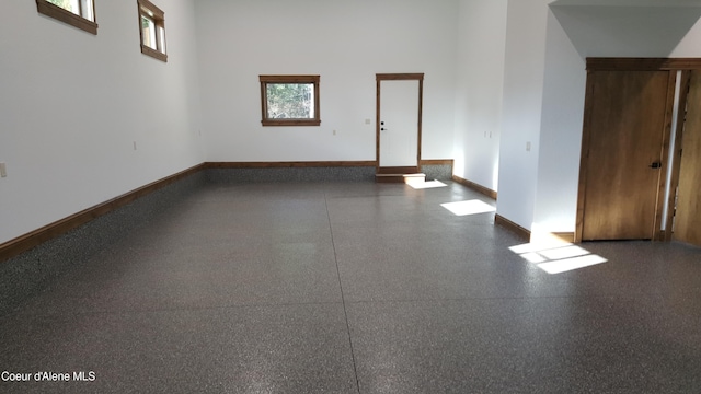 11671 N Spiraea Ln, Hayden, ID 83835 - unfurnished room featuring speckled floor, plenty of natural light, baseboards, and a high ceiling