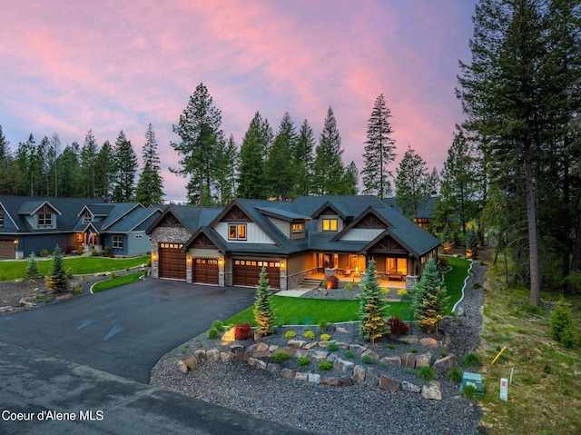 11671 N Spiraea Ln, Hayden, ID 83835 - log cabin with a porch, asphalt driveway, a garage, and stone siding