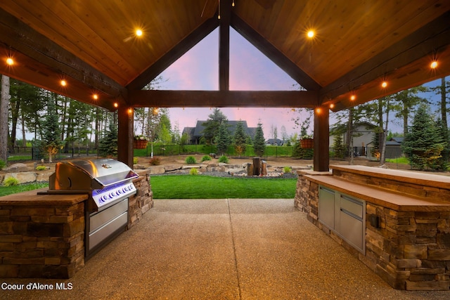 11671 N Spiraea Ln, Hayden, ID 83835 - patio terrace at dusk featuring an outdoor kitchen, a gazebo, and a grill