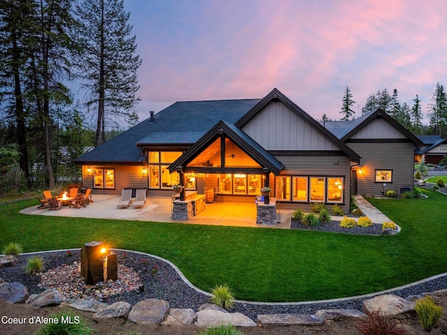 11671 N Spiraea Ln, Hayden, ID 83835 - back of property featuring an outdoor fire pit, a lawn, board and batten siding, and a patio