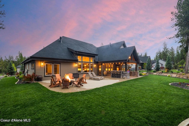 11671 N Spiraea Ln, Hayden, ID 83835 - rear view of property with a fire pit, a patio area, a lawn, and a shingled roof