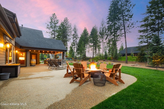 11671 N Spiraea Ln, Hayden, ID 83835 - patio terrace at dusk featuring a fire pit and a yard