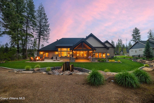 11671 N Spiraea Ln, Hayden, ID 83835 - back of house at dusk featuring a patio area and a lawn