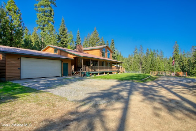 31582 E Hayden Lake Rd, Hayden, ID 83835 - view of front of house with an attached garage, covered porch, driveway, and a front lawn
