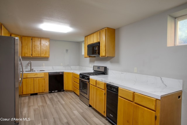 31582 E Hayden Lake Rd, Hayden, ID 83835 - kitchen with black appliances, light countertops, light wood finished floors, and a sink