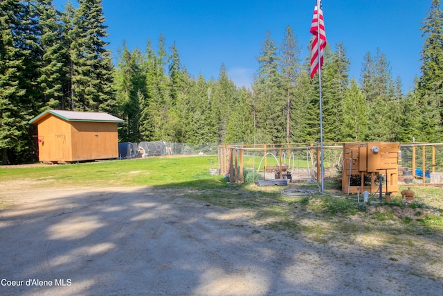 31582 E Hayden Lake Rd, Hayden, ID 83835 - view of yard with an outdoor structure, a forest view, a storage shed, and fence
