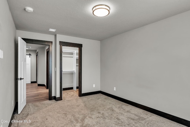 2878 N Callary St, Post Falls, ID 83854 - unfurnished bedroom with a closet, a textured ceiling, baseboards, carpet flooring, and a spacious closet
