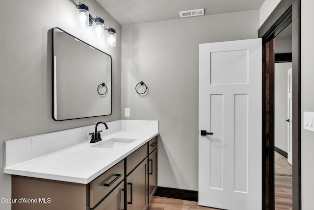 2878 N Callary St, Post Falls, ID 83854 - bathroom with vanity, baseboards, visible vents, and wood finished floors