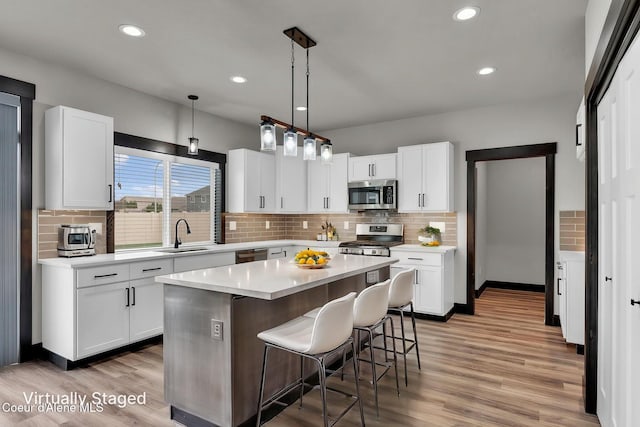 2878 N Callary St, Post Falls, ID 83854 - kitchen with a sink, white cabinetry, light countertops, appliances with stainless steel finishes, and decorative backsplash
