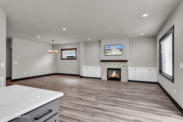 2878 N Callary St, Post Falls, ID 83854 - unfurnished living room with a fireplace, a chandelier, recessed lighting, and wood finished floors
