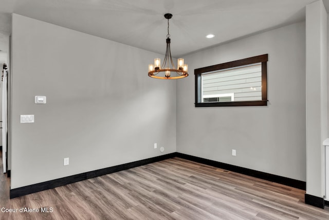 2878 N Callary St, Post Falls, ID 83854 - empty room featuring an inviting chandelier, baseboards, and wood finished floors