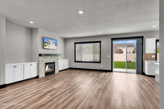 2878 N Callary St, Post Falls, ID 83854 - unfurnished living room featuring light wood-style floors, a fireplace, baseboards, and recessed lighting