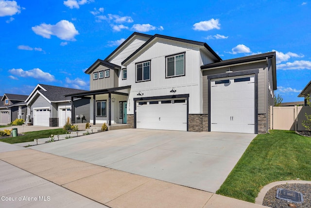 2878 N Callary St, Post Falls, ID 83854 - view of front of home with a front yard, fence, covered porch, concrete driveway, and stone siding