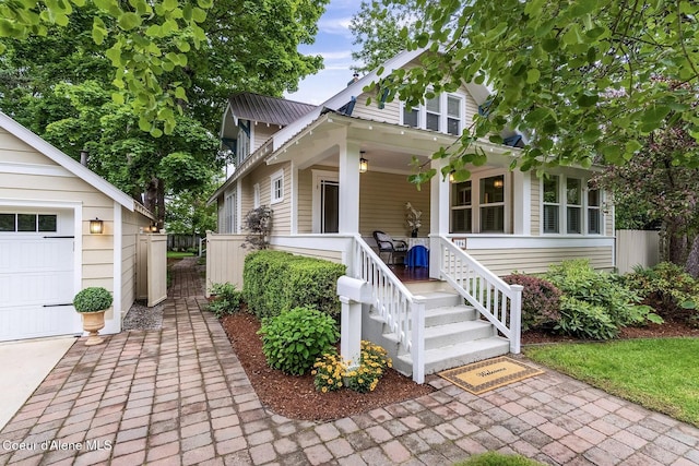306 S Huron Ave, Sandpoint, ID 83864 - view of front of home featuring a garage, covered porch, fence, and metal roof