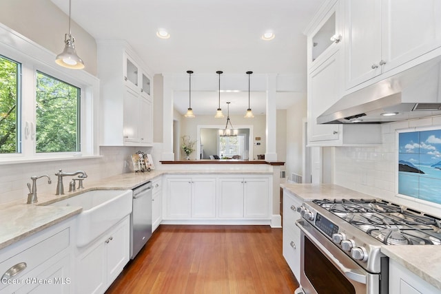 306 S Huron Ave, Sandpoint, ID 83864 - kitchen with a sink, white cabinets, under cabinet range hood, appliances with stainless steel finishes, and tasteful backsplash