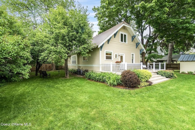 306 S Huron Ave, Sandpoint, ID 83864 - back of property featuring metal roof, a deck, fence, and a lawn