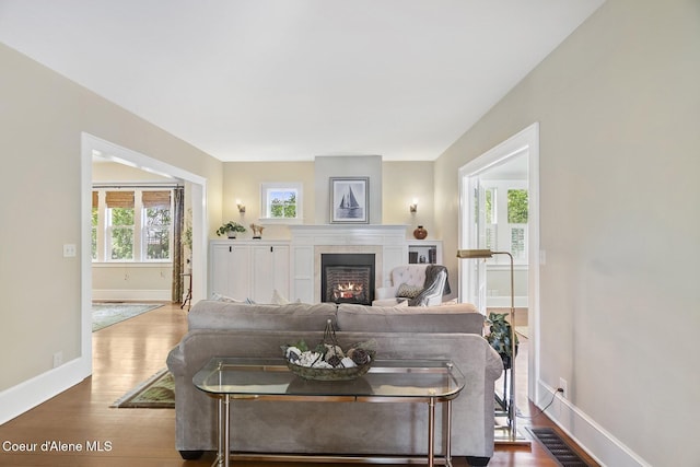 306 S Huron Ave, Sandpoint, ID 83864 - living room with visible vents, baseboards, a tiled fireplace, and wood finished floors