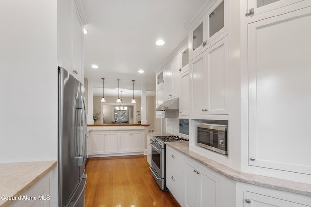 306 S Huron Ave, Sandpoint, ID 83864 - kitchen with stainless steel appliances, pendant lighting, light wood-style flooring, glass insert cabinets, and white cabinets