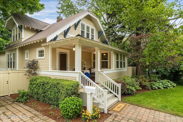 306 S Huron Ave, Sandpoint, ID 83864 - bungalow with a porch, a chimney, fence, and metal roof