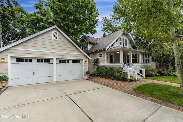 306 S Huron Ave, Sandpoint, ID 83864 - view of front of home with metal roof, a porch, an outbuilding, and a garage