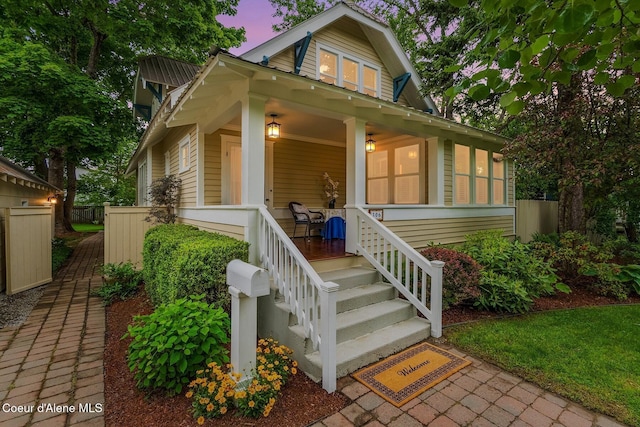 306 S Huron Ave, Sandpoint, ID 83864 - view of front of home with a gambrel roof, covered porch, and fence