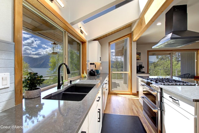 17718 E Cape Horn Rd, Bayview, ID 83803 - kitchen with range with two ovens, exhaust hood, a sink, light stone countertops, and recessed lighting