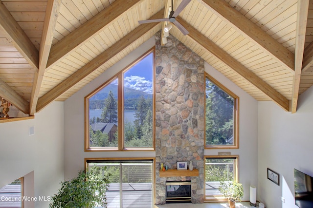 17718 E Cape Horn Rd, Bayview, ID 83803 - unfurnished living room featuring beamed ceiling, wooden ceiling, high vaulted ceiling, a stone fireplace, and a ceiling fan