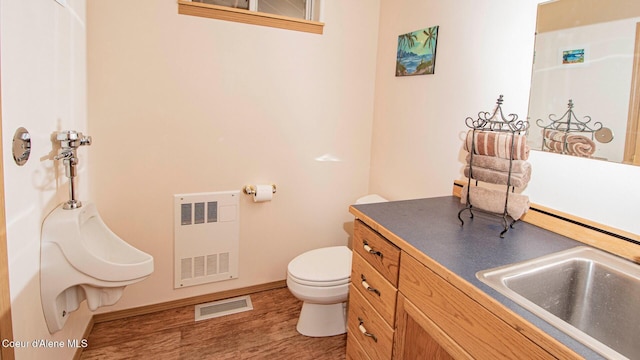 6616 Comanche St, Bonners Ferry, ID 83805 - bathroom with toilet, radiator heating unit, wood finished floors, visible vents, and baseboards