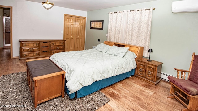 6616 Comanche St, Bonners Ferry, ID 83805 - bedroom featuring a wall mounted AC, a closet, baseboard heating, and wood finished floors