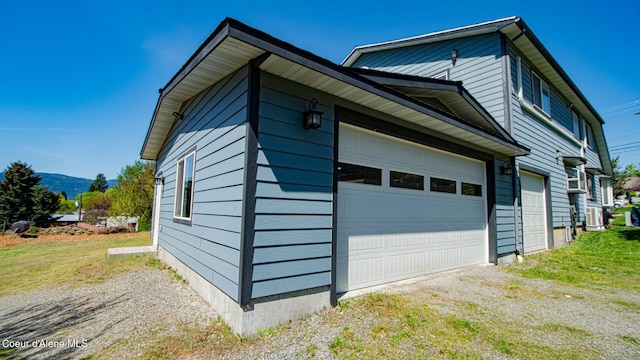 6616 Comanche St, Bonners Ferry, ID 83805 - view of side of property featuring central air condition unit, an attached garage, and driveway