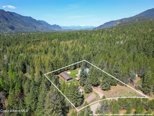 birds eye view of property featuring a forest view and a mountain view