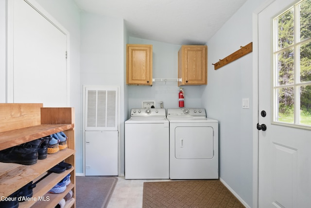 laundry area featuring cabinet space, independent washer and dryer, light floors, a heating unit, and baseboards