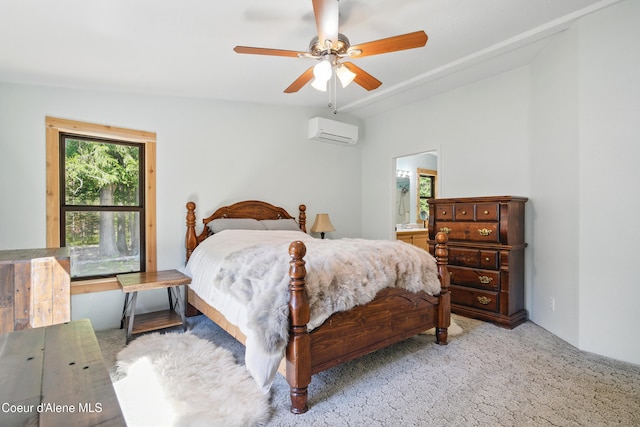 bedroom featuring connected bathroom, a wall mounted AC, carpet flooring, and a ceiling fan