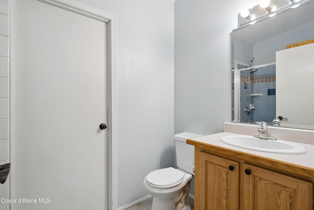 bathroom featuring vanity, toilet, and a tile shower