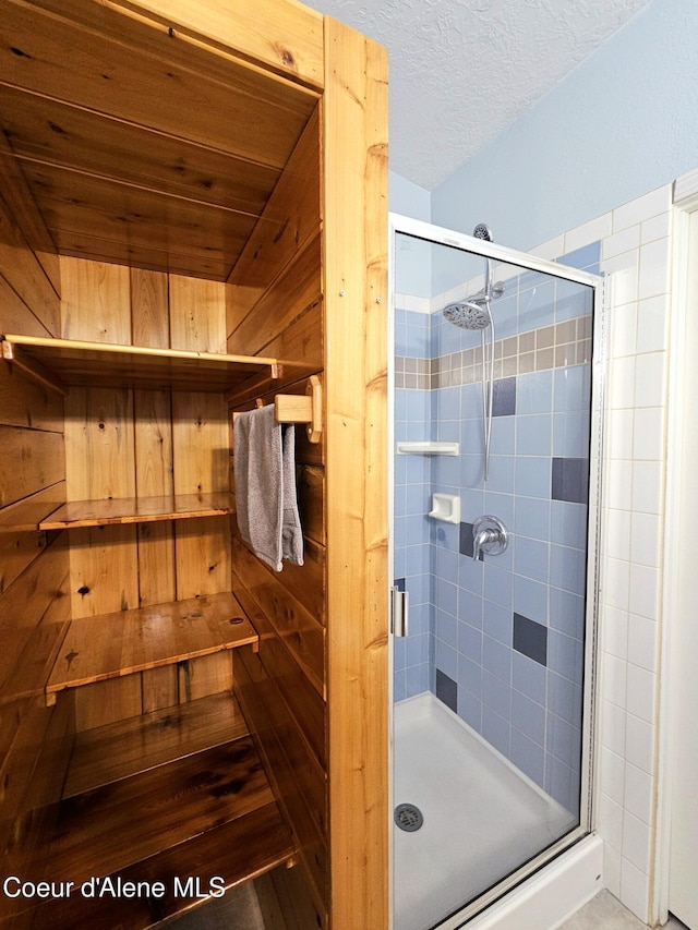 full bathroom featuring a stall shower and a textured ceiling