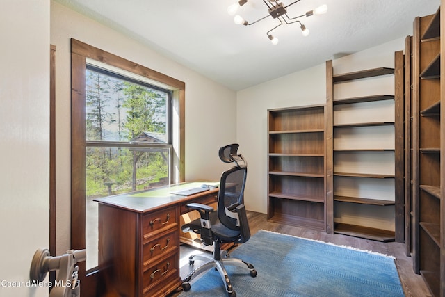 office space featuring vaulted ceiling and a notable chandelier