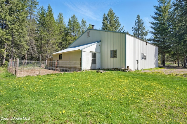 view of pole building featuring fence and a lawn
