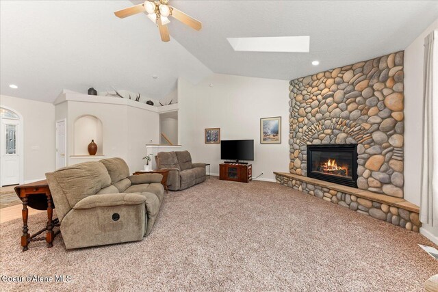 12795 N Yearling Cir, Hayden, ID 83835 - carpeted living area featuring vaulted ceiling with skylight, baseboards, ceiling fan, a stone fireplace, and recessed lighting