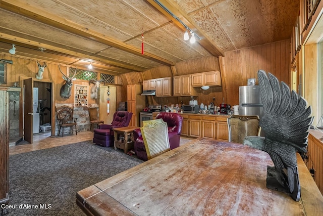 760 Fox Glen Rd, Sandpoint, ID 83864 - kitchen featuring wood walls, beam ceiling, appliances with stainless steel finishes, and under cabinet range hood