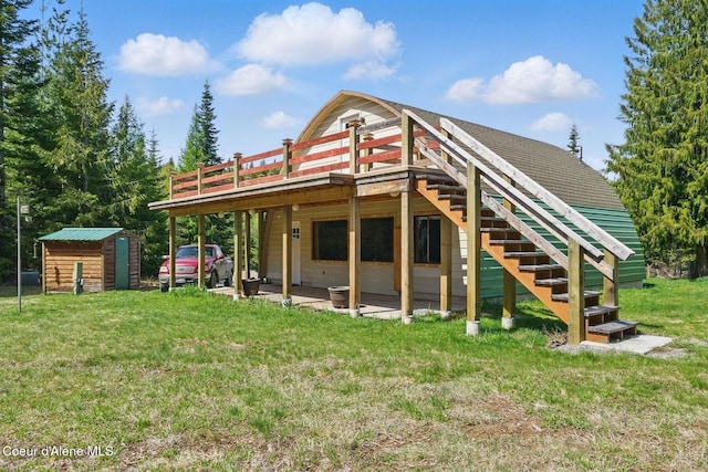 760 Fox Glen Rd, Sandpoint, ID 83864 - rear view of house with an outbuilding, a storage unit, a deck, a yard, and stairs