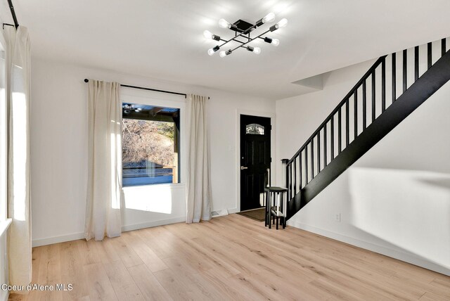 513 Mission Ave, Kellogg, ID 83837 - foyer entrance with an inviting chandelier, stairway, wood finished floors, and baseboards