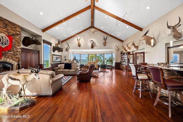 living area featuring high vaulted ceiling, wood finished floors, beam ceiling, a fireplace, and recessed lighting