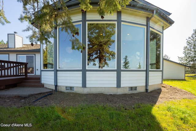 view of side of property with a wooden deck and a sunroom
