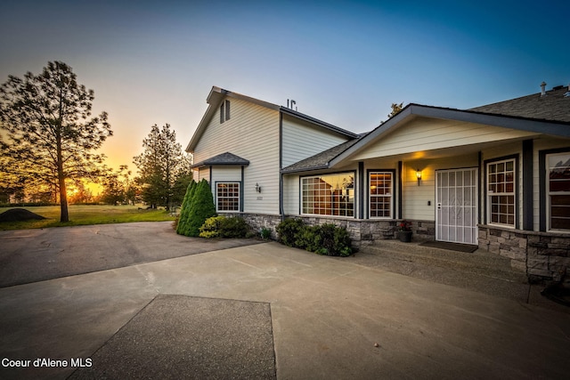 view of front of property with stone siding and a shingled roof