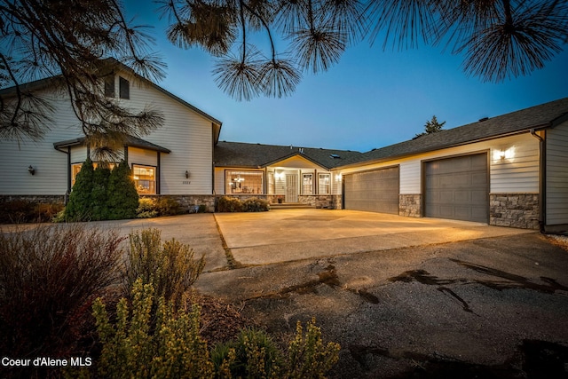 view of front of home with stone siding, concrete driveway, and an attached garage