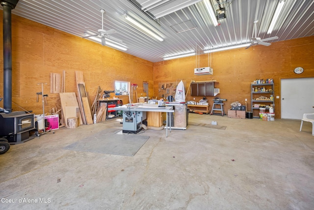 garage featuring a workshop area, a wood stove, and a wall unit AC